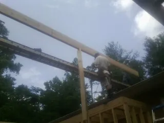 Carpenter setting a ridge beam over a new addition frame — Ice Dam Removal by Roofing Brothers in Dallastown