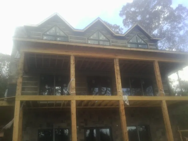 Dormers and porch framing on a large log home under construction — Roof Coating work by our crew in Dallastown