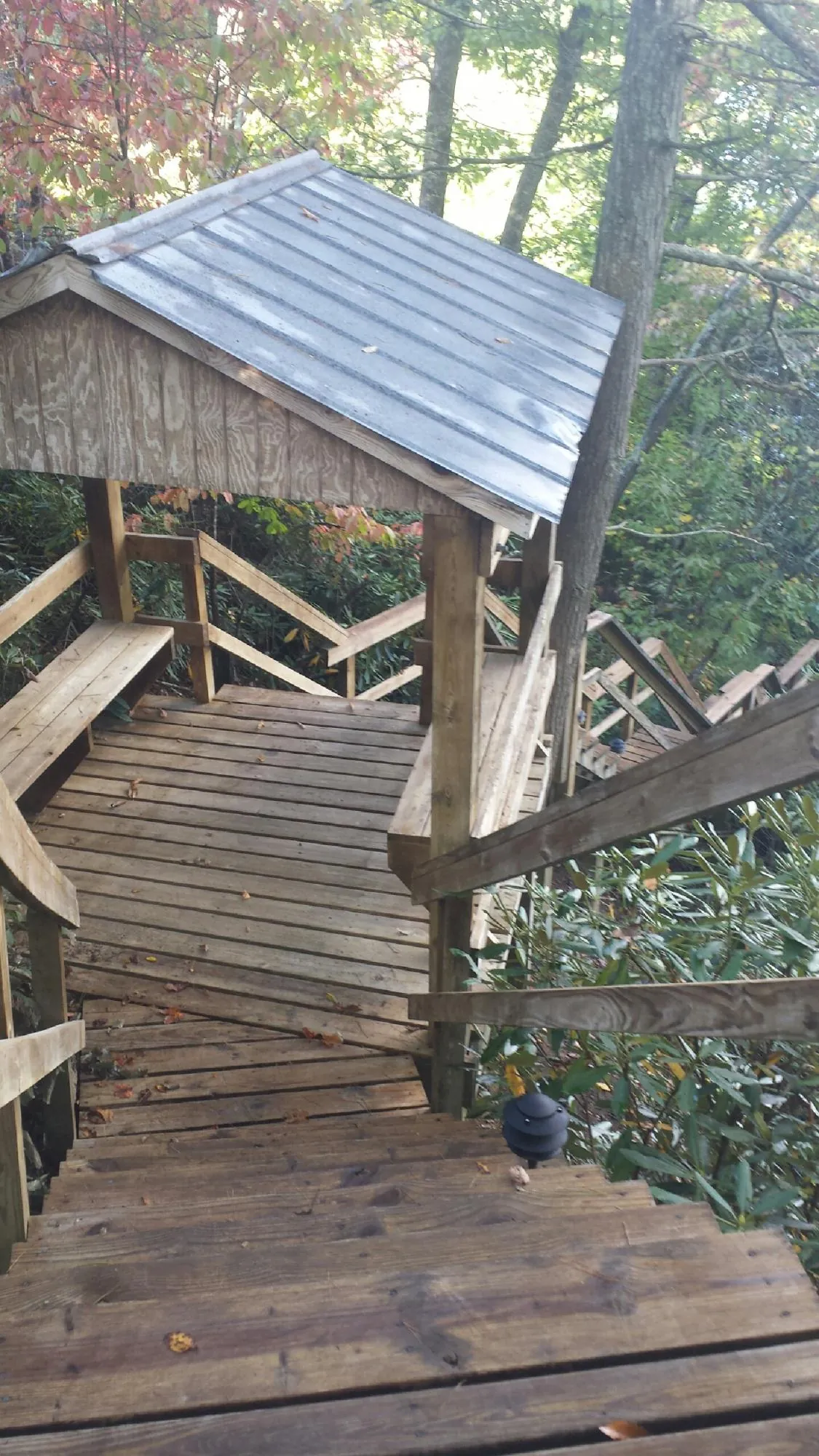 Metal roofed shelter over wooden steps on a wooded walkway — Skylight Repair & Installation work by our crew in Dallastown